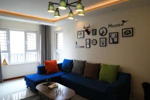 Xiazangtuan阅海民宿青岛北站海景公寓的客厅配有蓝色沙发及色彩缤纷的枕头