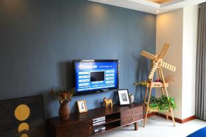 Xiazangtuan阅海民宿青岛北站海景公寓的一间客厅,客厅的蓝色墙壁上配有电视