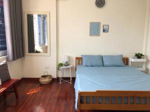 河内Khai Homestay的一间卧室配有一张蓝色床单,铺有木地板