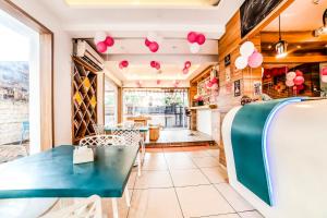 浦那FabHotel Imperio Baner的一间设有蓝色桌子和粉红色气球的餐厅