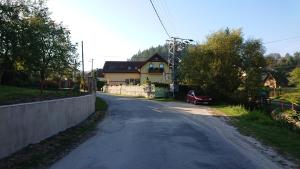 SúľovApartmány Súľov 183的一条空的公路,上面有房子和一辆红色的汽车