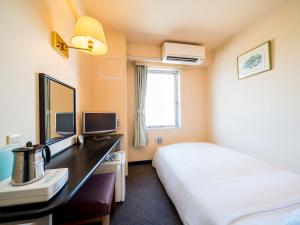 松阪市Super Hotel Matsusaka的配有一张床和一张书桌的酒店客房