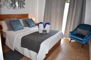 拉特吉塔VILLA MOLEIRO- LA TEJITA的一间卧室配有一张带蓝椅和鞋子的床