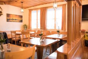Kirchberg托根博格霍夫酒店的餐厅设有木桌、椅子和窗户。