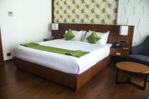 戈德亚姆HOTEL CEASAR PALACE的一间卧室配有一张带绿毯的大床