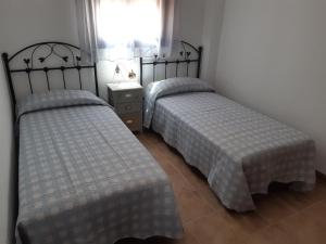 丰特埃里多斯Alojamiento La Fuente的带窗户的客房内设有两张单人床。