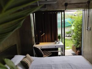 Bangkok YaiTHE HOG的一间卧室配有一张床、一张书桌和一个窗户。