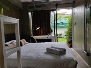 Bangkok YaiTHE HOG的一间卧室设有两张床、一张桌子和一个窗口。