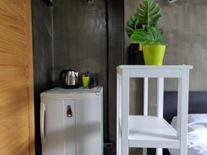 Bangkok YaiTHE HOG的白色的橱柜,旁边是白色的椅子和植物