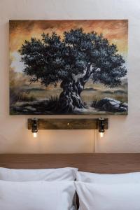 皮特斯迪亚Ferienhaus Aretoussa的上床墙上一棵树的画