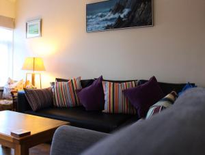 RushThe Beachfront Retreat的客厅配有带色彩缤纷枕头的黑色沙发