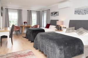 MullinavatThe Garrandarragh Inn的酒店客房配有两张床和一张书桌