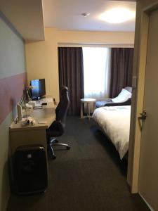 滨松滨松大和鲁内酒店的酒店客房配有一张床和一张带电脑的书桌