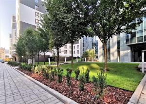 华沙Come&Stay apartments Wola的一座有树木和草的公园