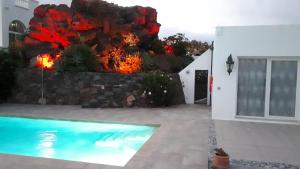 蒂亚斯Villa Essence - a unique detached villa with heated private pool, hottub, gardens, patios and stunning views!的一座带游泳池和岩石墙的房子