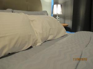 新山E Life D Summit Residences With Wifi & Netflix的一张带白色床单和枕头的床