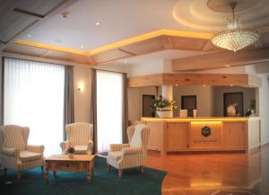 贝希特斯加登舍瓦本维特酒店的酒店大堂设有椅子和前台