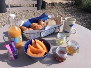 RiansLe Pod de L'Adret的一张桌子,上面放着一篮面包和一碗胡萝卜