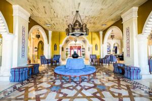 赫尔格达Sunrise Mamlouk Palace Resort的大房间设有蓝色的椅子和桌子
