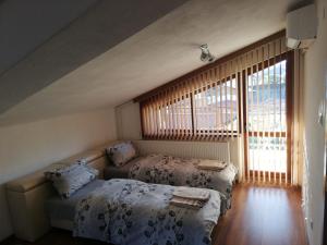 卡洛费尔стаи за гости Диневи的一间卧室设有两张床和窗户。
