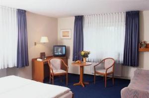 汉堡考克斯伽尼酒店的酒店客房带一张床、一张桌子和椅子