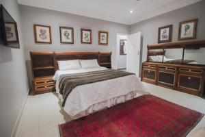 约翰内斯堡The Afropolitan的一间卧室配有床、镜子和红色地毯