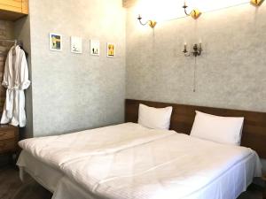 第比利斯T2&T3 Apartments LEVANTO的一间卧室配有两张带白色床单的床