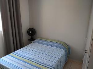 贝洛奥里藏特Residencial的一间带一张床和风扇的小卧室
