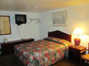科蒂奇格罗夫格罗夫小屋休闲客栈的酒店客房设有一张床和墙上的电视