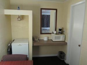 科蒂奇格罗夫格罗夫小屋休闲客栈的一间配有微波炉和镜子的小浴室