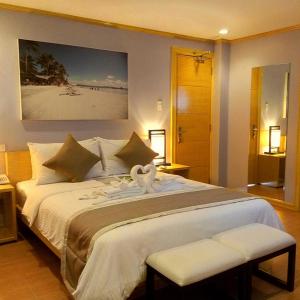 长滩岛长滩岛海滨时光酒店的一间卧室配有一张大床,上面有天鹅