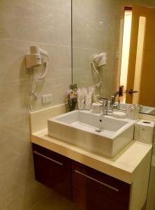 长滩岛长滩岛海滨时光酒店的浴室设有白色水槽和镜子
