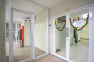 茂物RedDoorz Apartment at Bogor Valley的走廊设有玻璃门和圣诞装饰