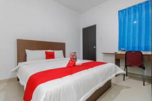 巴淡岛中心克普利购物中心附近红门酒店的一间卧室配有一张带红色毯子的大床