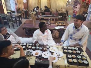 杭州望达斯旅舍的一群人坐在桌子旁,拿着纸杯蛋糕