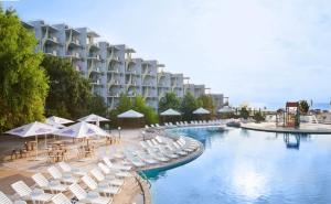 阿尔贝纳拉古纳海滩酒店的酒店设有带椅子和遮阳伞的游泳池