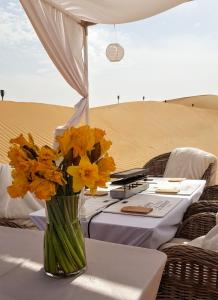 迪拜STARLIGHT CAMP的沙漠桌子上一束黄色花