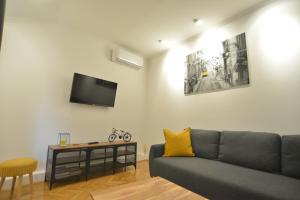 贾科沃Apartman LENA的客厅配有沙发和墙上的电视
