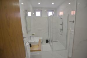 贾科沃Apartman LENA的带淋浴和盥洗盆的白色浴室