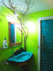 富国Phu Nam House - Resort的绿色浴室设有水槽,墙上有一棵树