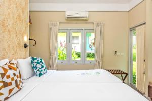 沙美岛赛考海滩度假酒店的卧室设有一张白色大床和一扇窗户。
