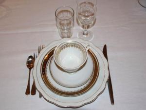 施特拉尔松德"Schwarzer Speicher" Stralsund的桌子,上面有盘子,碗,叉子和刀子