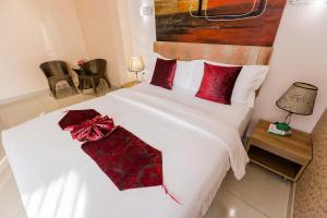 清迈清迈红燕酒店的卧室配有带红色枕头的白色床