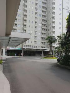 万隆威尔公寓 - 帕拉亚甘住宿的一个大楼前的一个空停车位