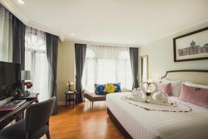 曼谷Daraya Boutique Hotel的酒店客房设有一张大床和一张书桌。