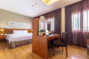 胡志明市Saigon Hotel的酒店客房配有一张床和一张带电脑的书桌