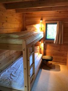 Marnardal曼达尔拉克希特酒店的小木屋内一间卧室配有两张双层床