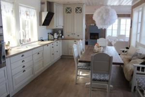 高尔Torshaug 4 bedroom cabin的厨房配有白色橱柜和桌椅
