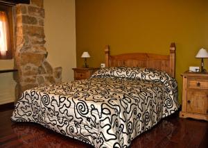奥尔塔-德圣胡安La Serra Rural的一间卧室配有一张带黑白色棉被的床