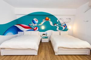 台东旅人驿站 - 米豆文旅的卧室配有两张壁画床。